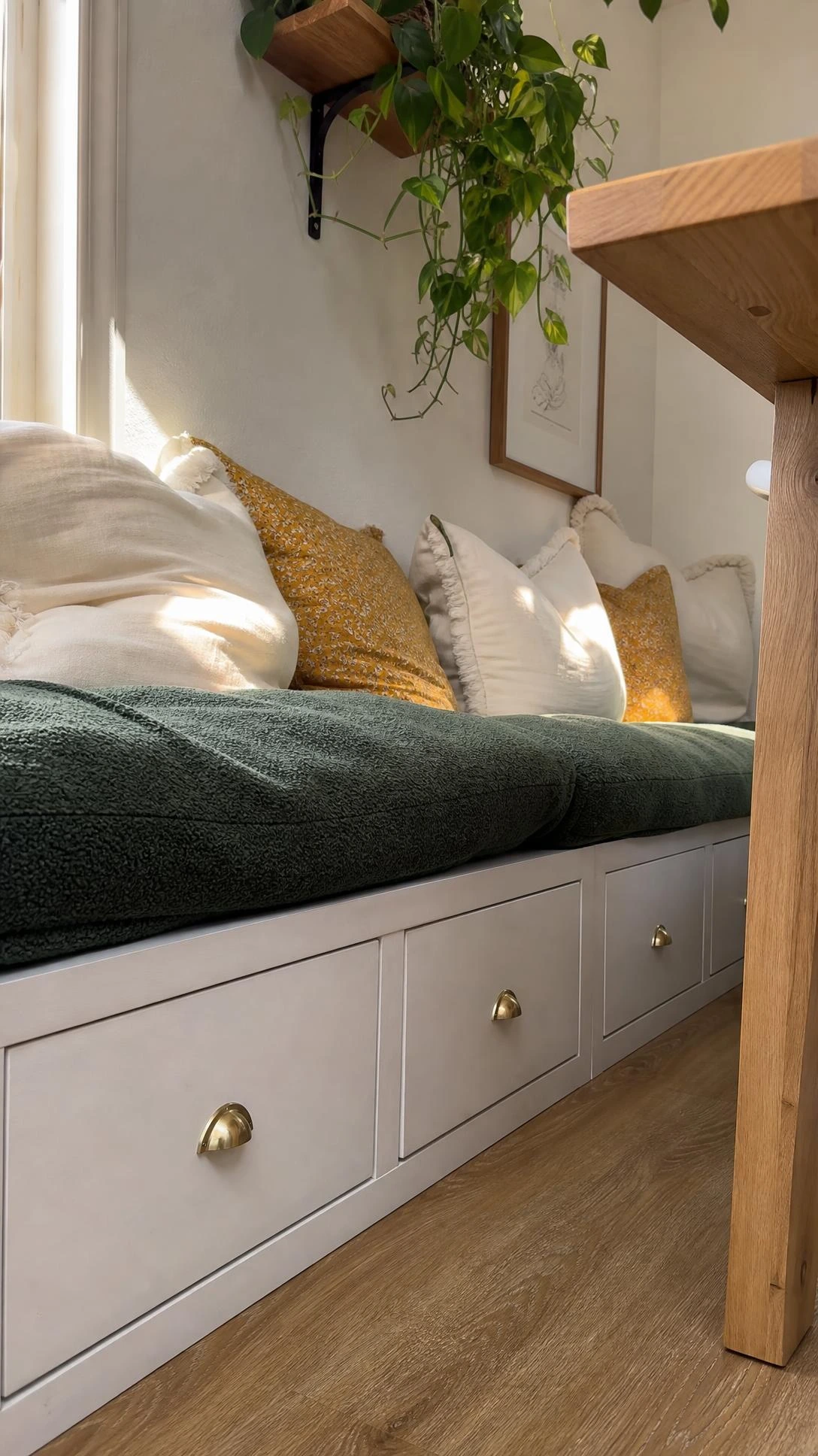 KALLAX shelving unit transformed into a built-in banquette bench in a cozy dining nook, showing how IKEA hacks can create custom-looking built-in furniture