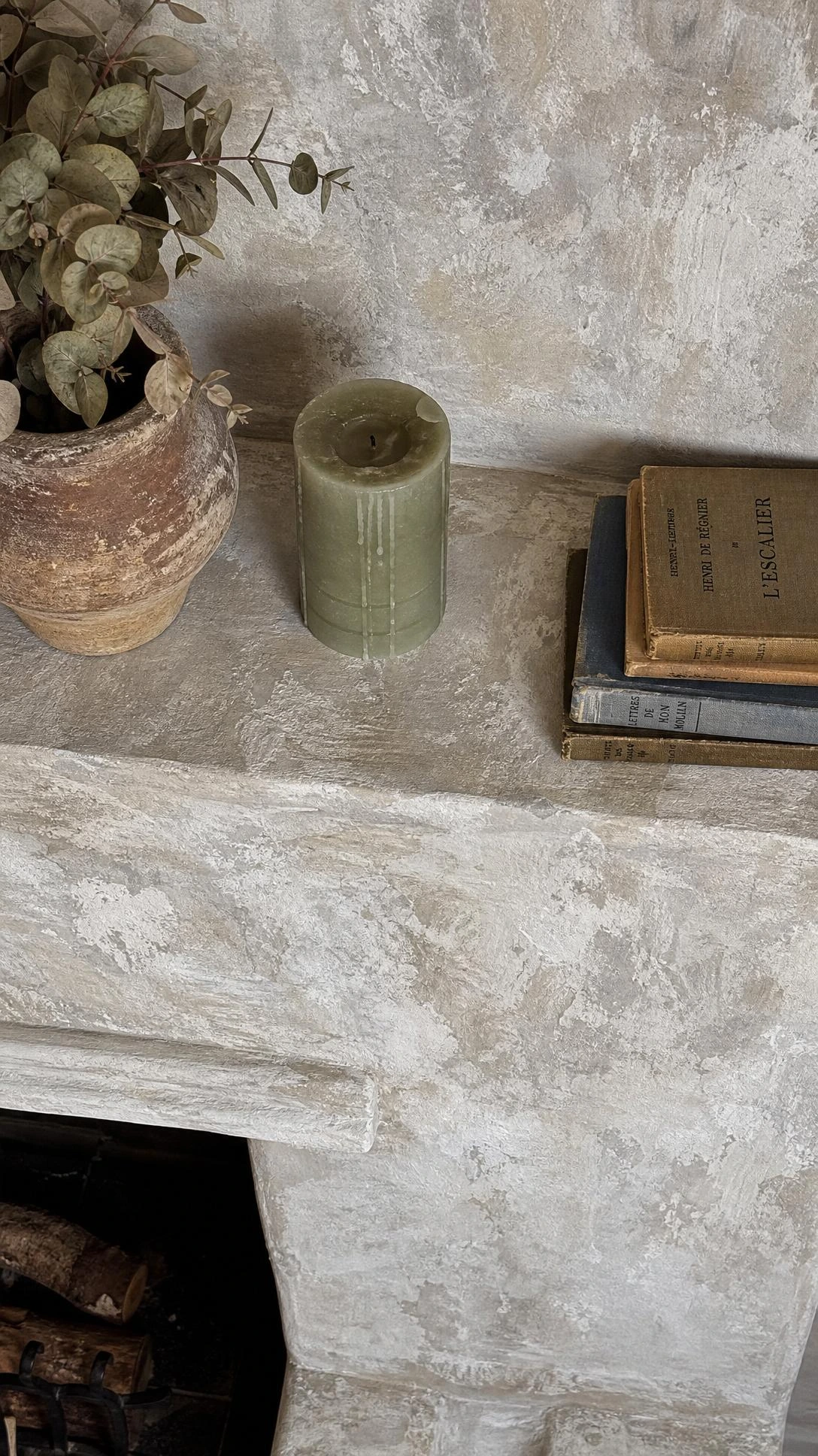 Limewash painted fireplace surround showing chalky white-over-grey mottled finish with cream and taupe undertones, capturing the aged European plaster texture