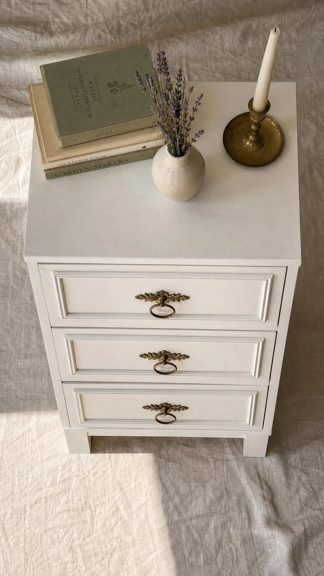 Overhead flat lay of a transformed IKEA RAST nightstand with white painted finish, applied molding, and vintage hardware — a classic IKEA hack upgrade