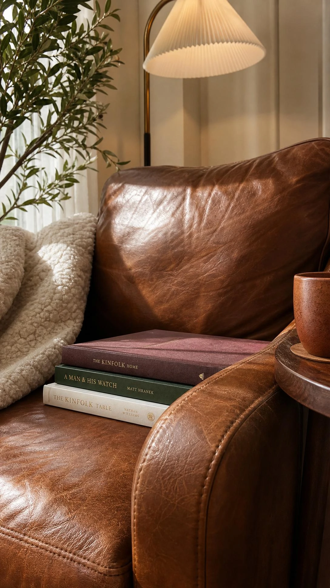 Close-up of a warm cognac brown leather reading chair showing full-grain leather texture, natural creasing, and rich surface detail that highlights quality craftsmanship