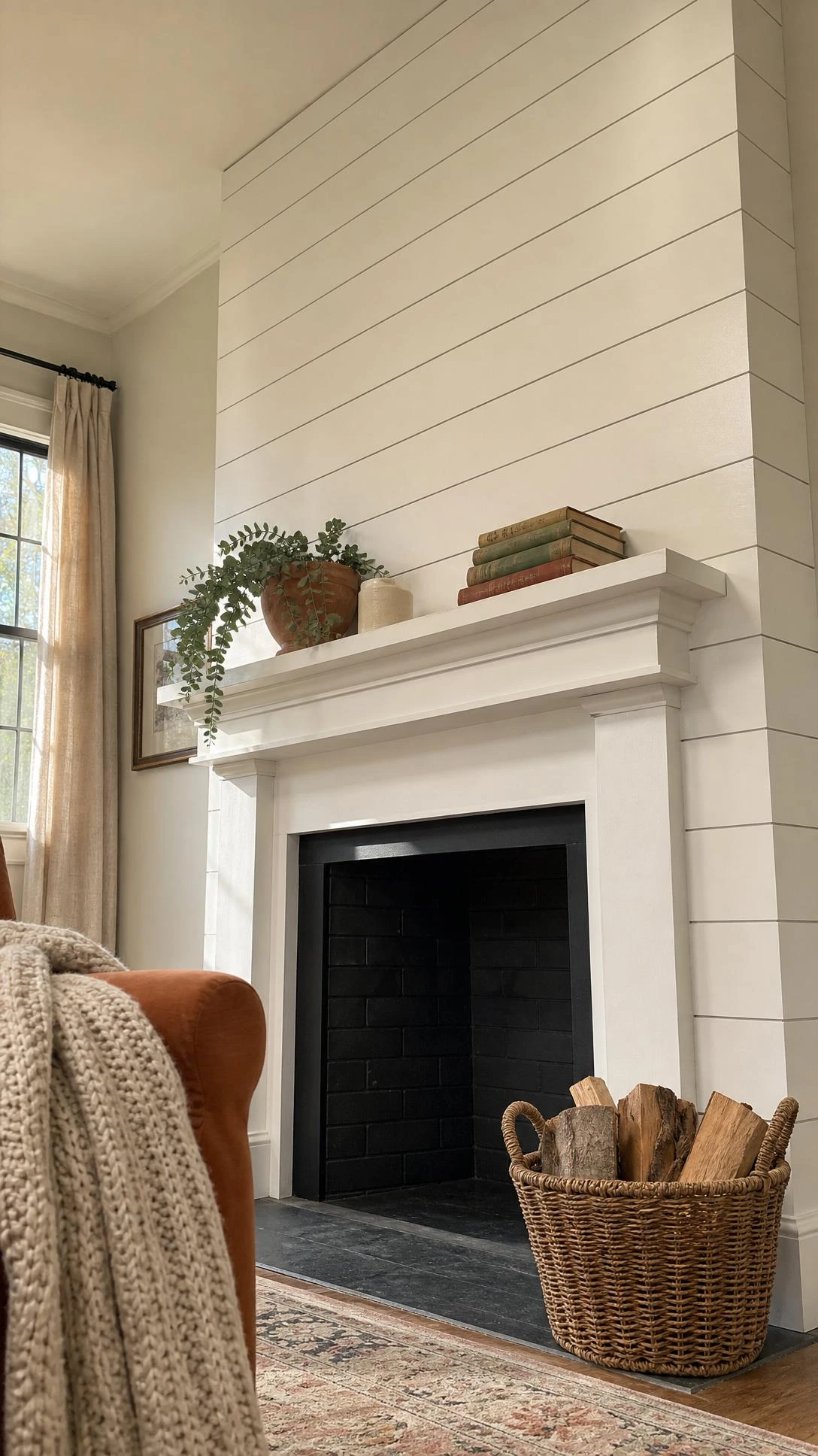 White shiplap fireplace surround with painted mantel in a warm sunlit living room — a crisp, budget-friendly fireplace makeover that transformed the entire space