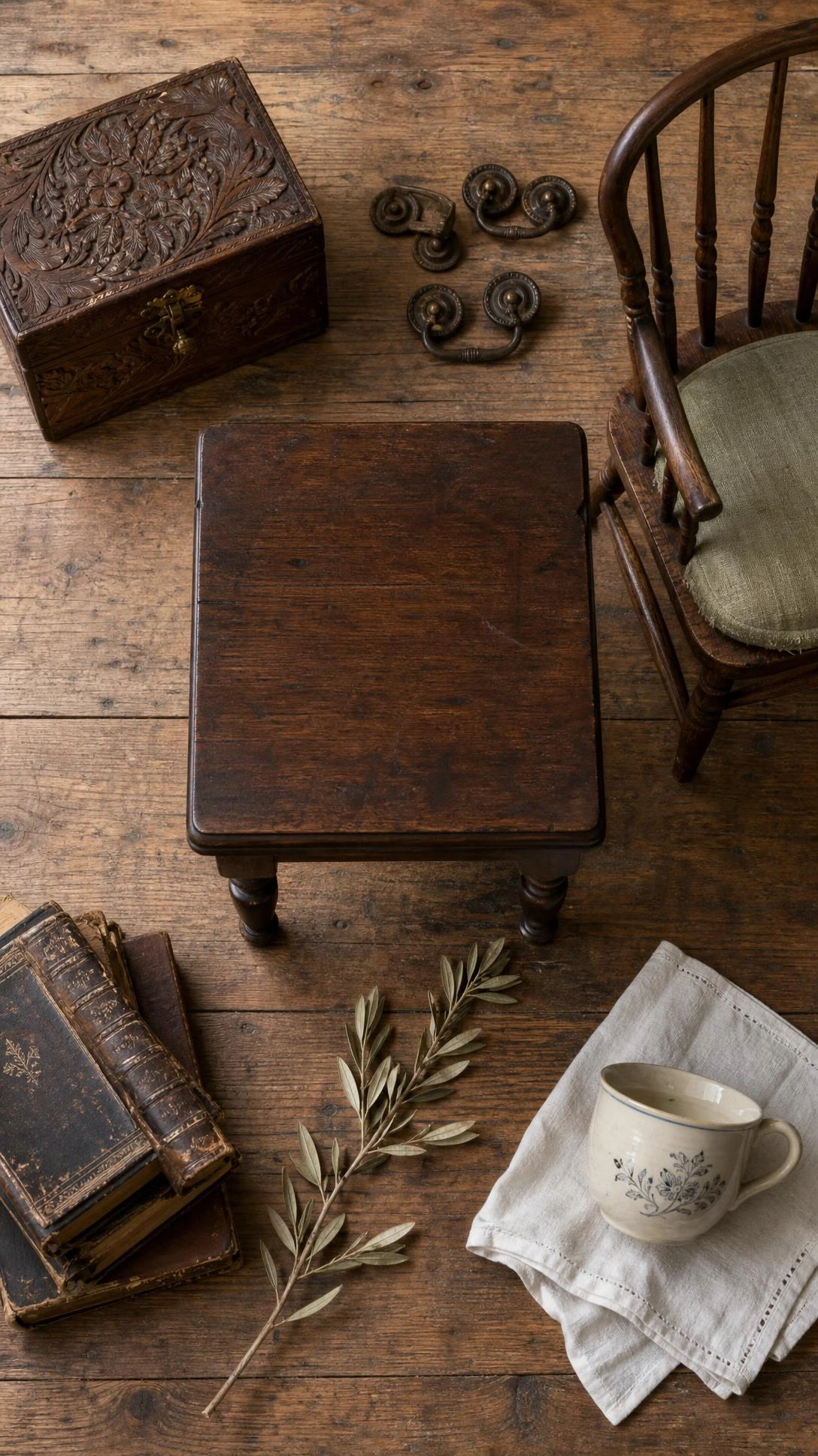 Dark walnut side table with turned legs and aged patina surrounded by antique wooden accessories on worn oak floor, showcasing English countryside furniture layering