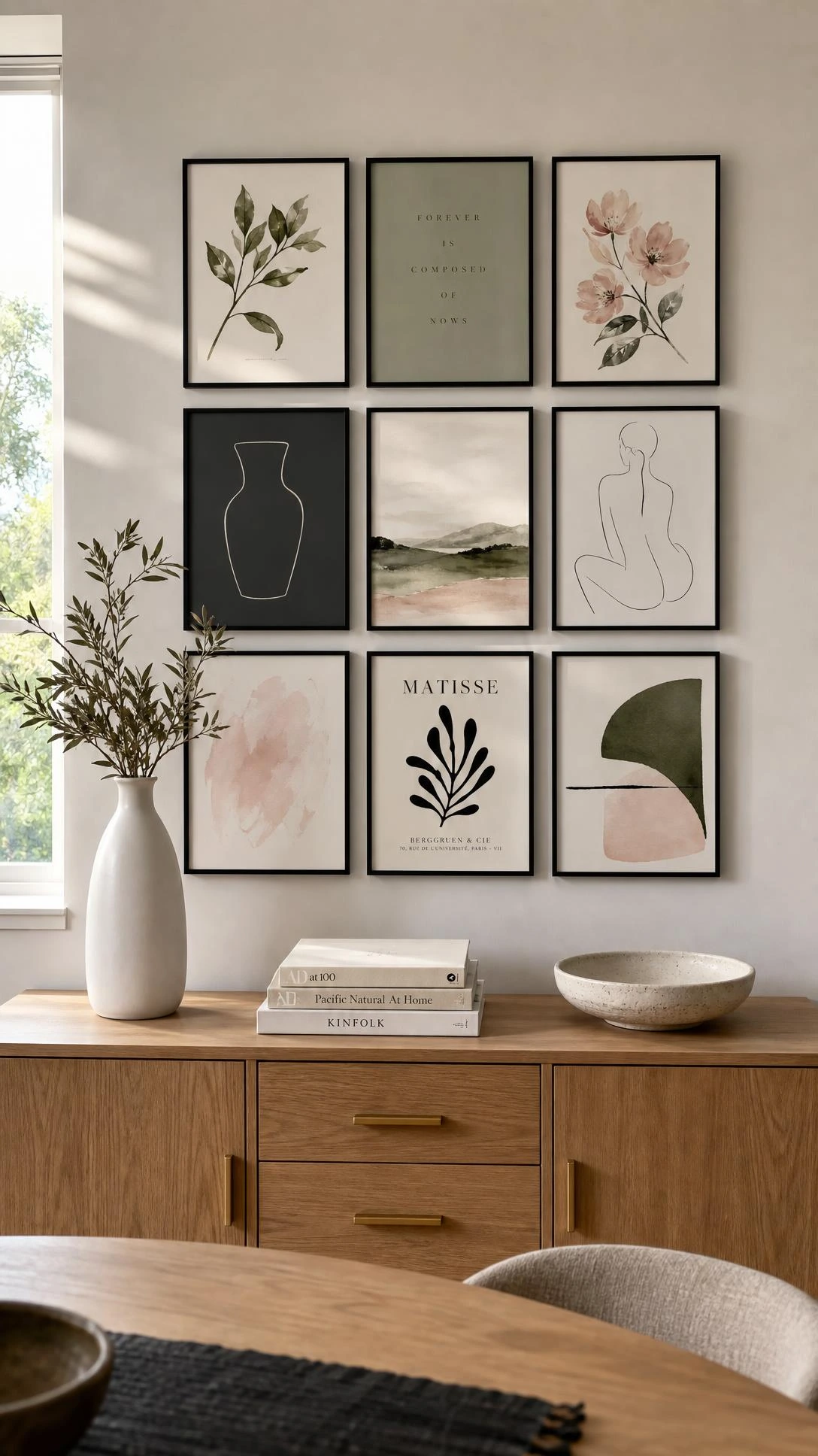 Nine black-framed art prints arranged in a 3x3 symmetrical grid above a warm wooden sideboard, showing how a dining room gallery wall creates structured visual impact