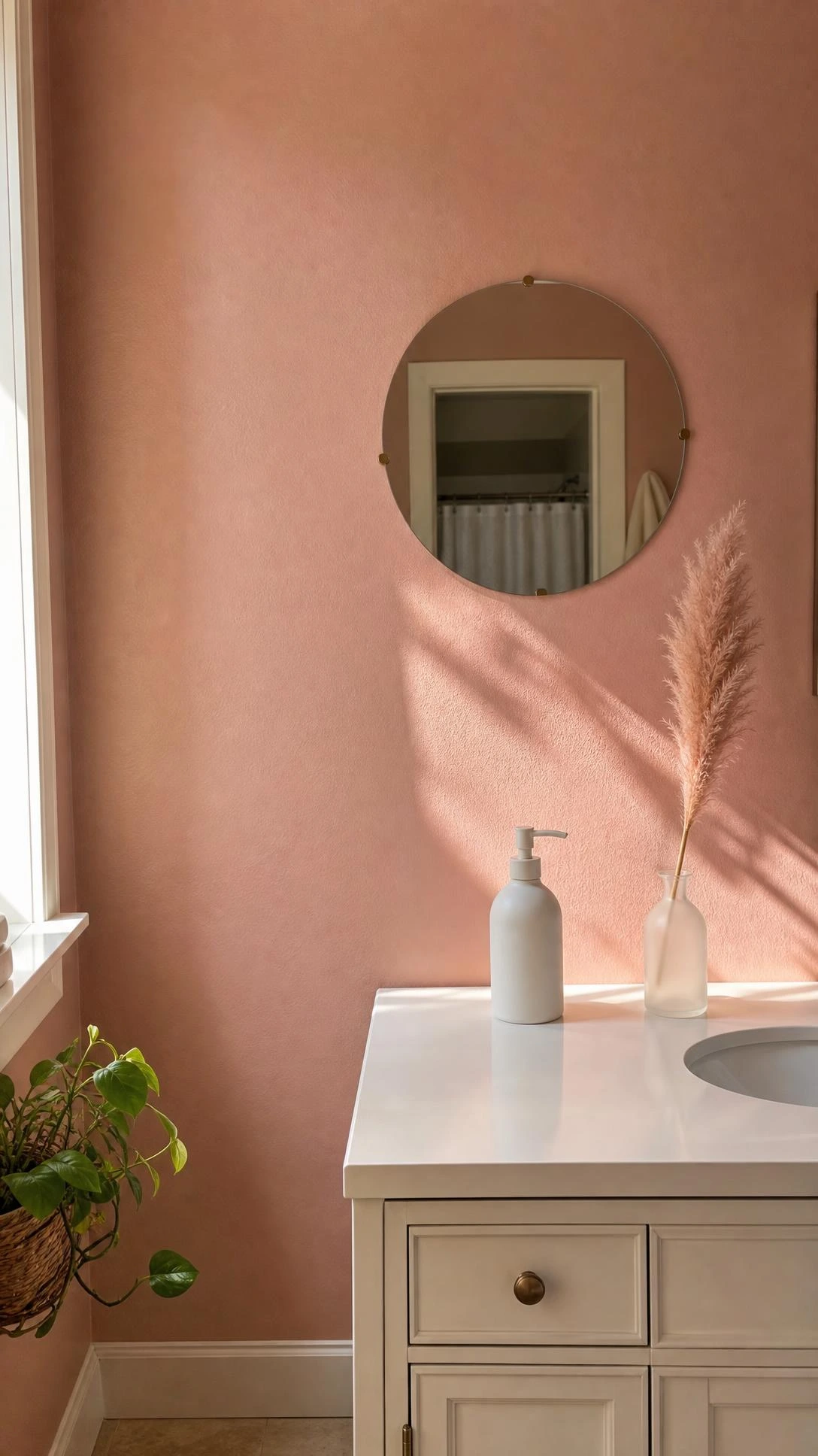 Freshly painted blush pink bathroom wall with warm dusty rose undertones, showing full coverage from baseboard to ceiling for a soft, muted aesthetic