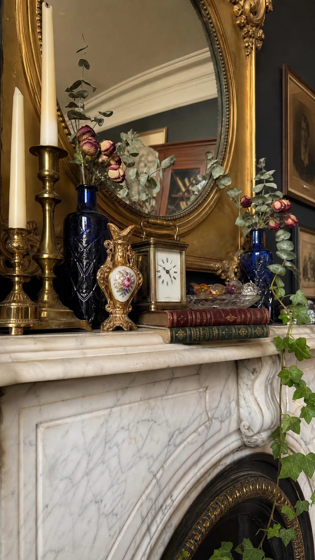 Victorian marble mantelshelf layered with an eclectic bric-a-brac display of ornate decorative objects, shot from hearth level to emphasize dramatic vertical height