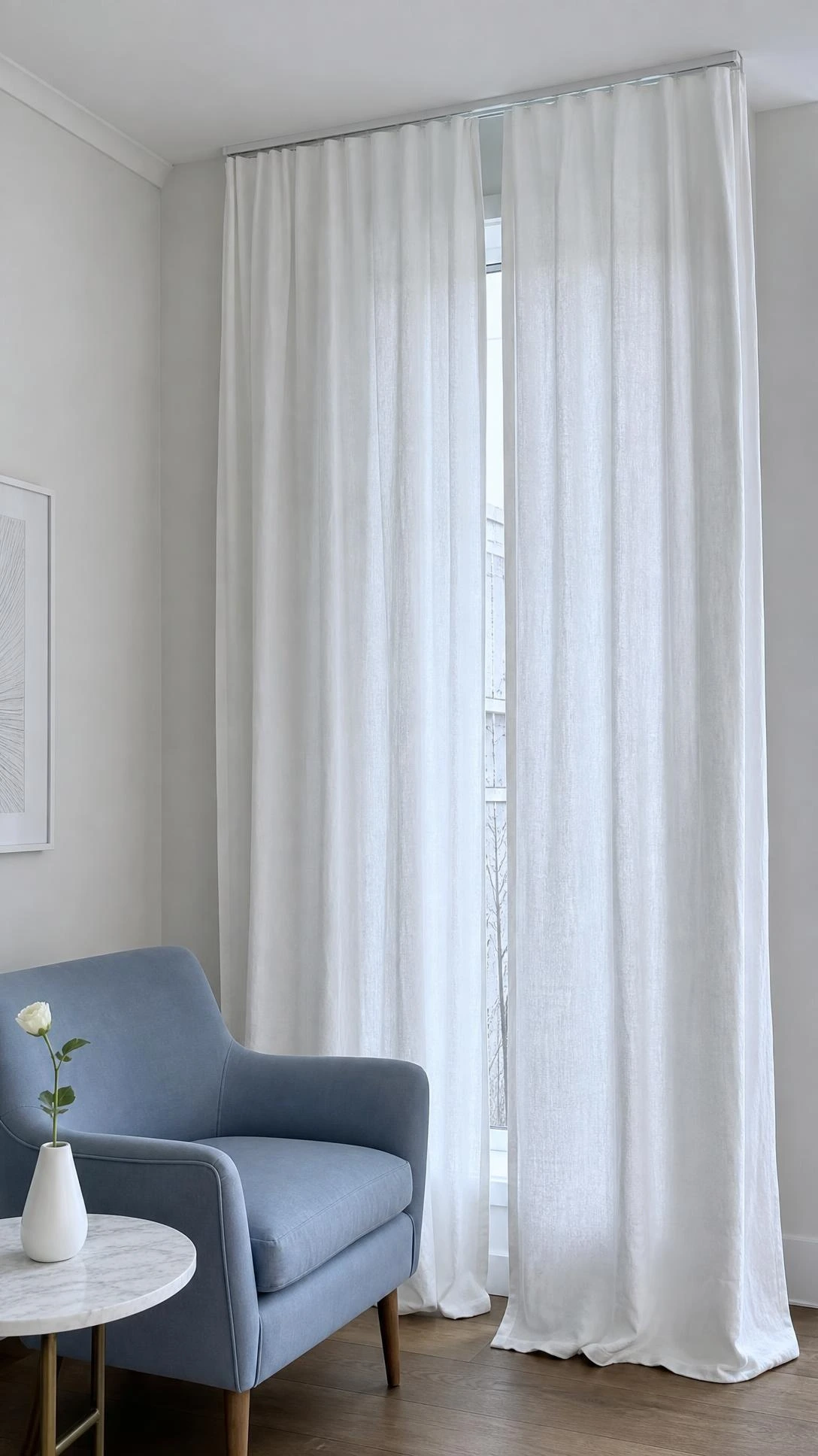 Bright white linen curtains in a north-facing living room where cool blue light makes the white look stark and cold against hardwood floors
