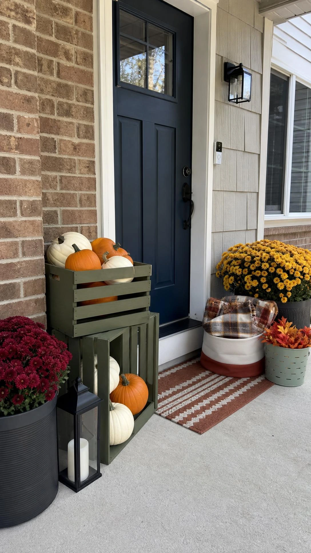 Budget crates and thrifted baskets styled on a suburban front porch with stacked olive crates, pumpkins, and mixed baskets for fall porch decorating ideas.