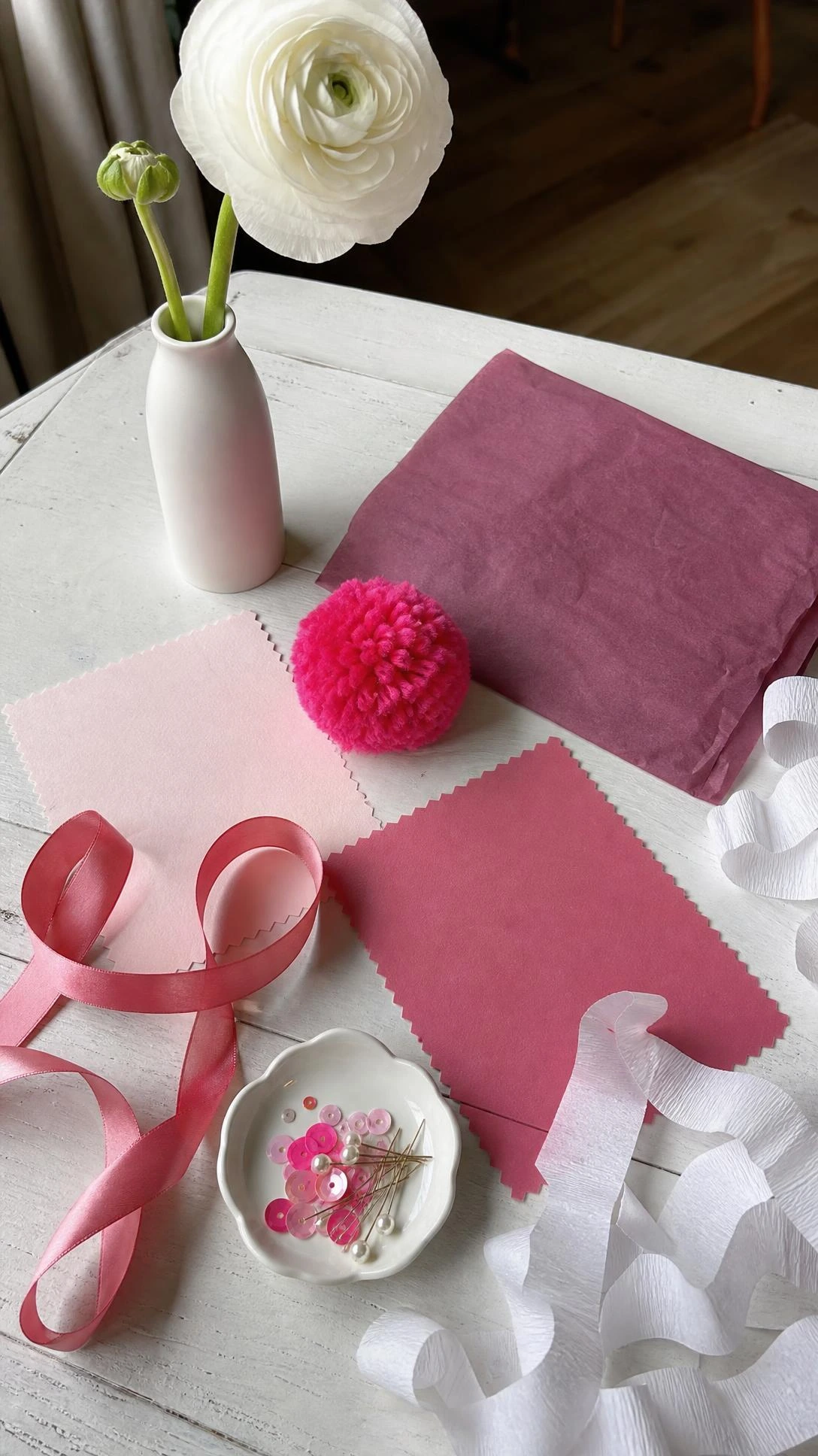 Blush, rose, and hot pink color swatches with ribbon samples laid on white wood, showing how to choose the right pink shade for birthday decor