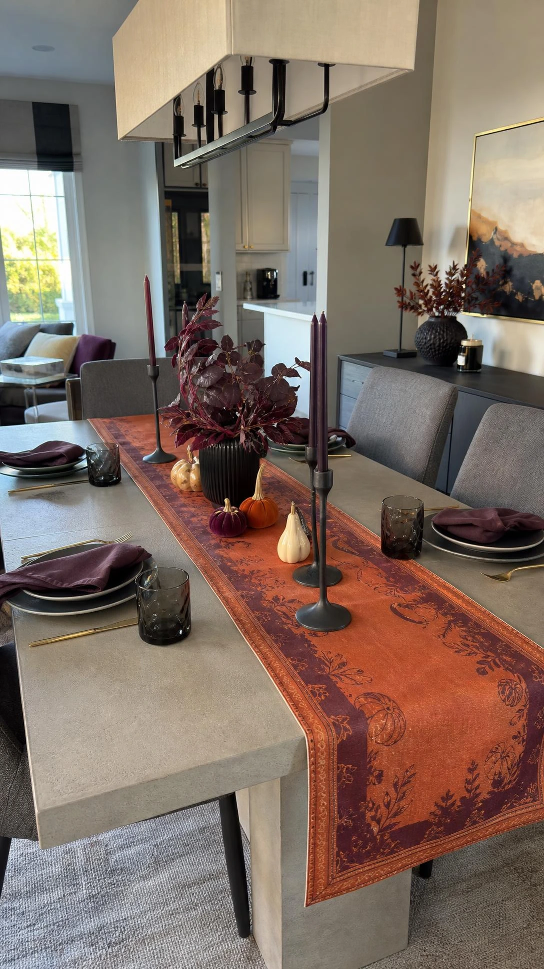 Stylish Halloween Home Decor table runner layered down a contemporary dining table, anchoring black place settings in a bright suburban dining area.