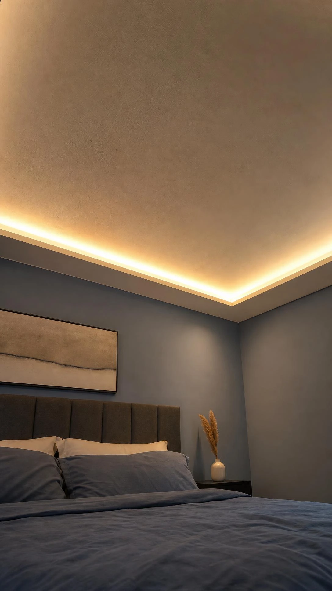 Hidden LED strip lights embedded in a smooth gypsum ceiling casting a warm amber glow across a modern bedroom, showing how indirect lighting transforms the entire mood of a space