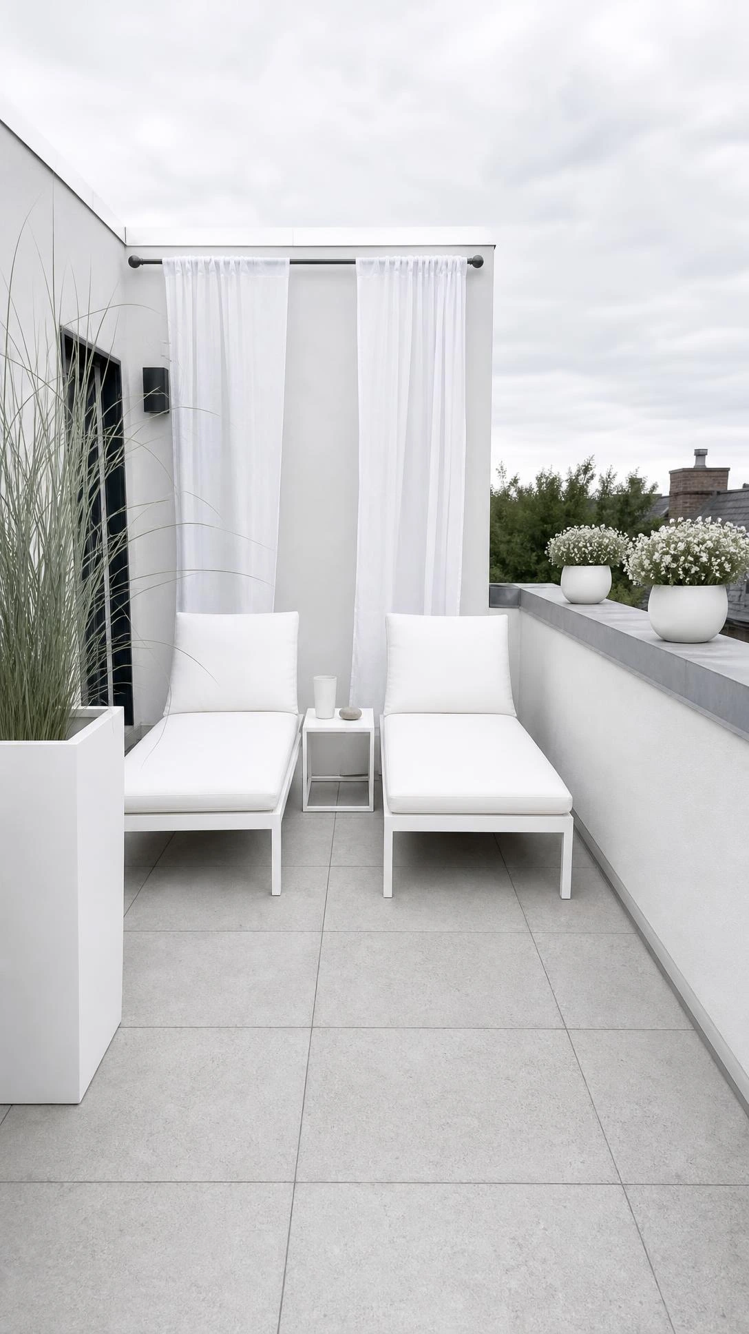 Small rooftop terrace with monochrome gray and white palette featuring concrete tile flooring and two white steel lounge chairs in a sleek modern layout