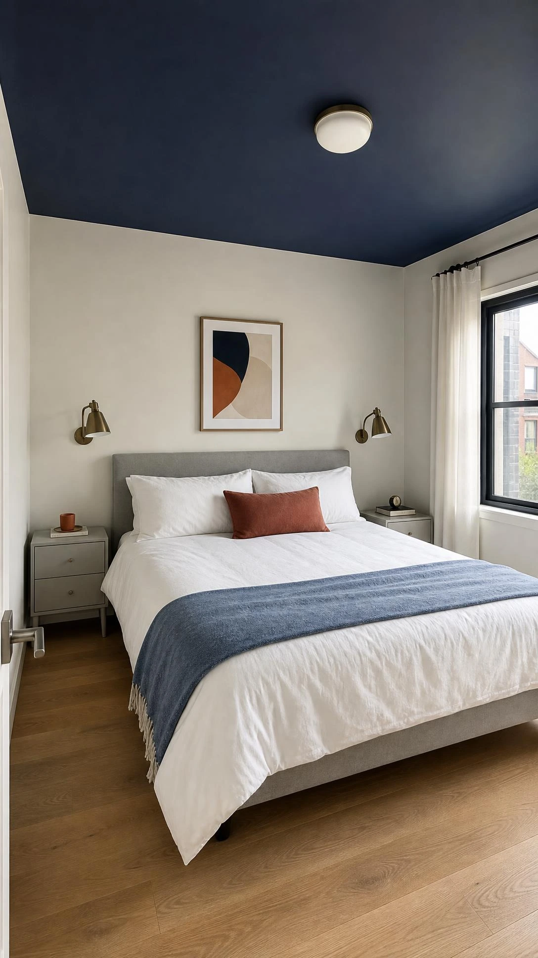 Small contemporary bedroom with a centered bed and navy-painted ceiling, a smart Navy Bedroom Ideas detail that adds depth to the compact space.