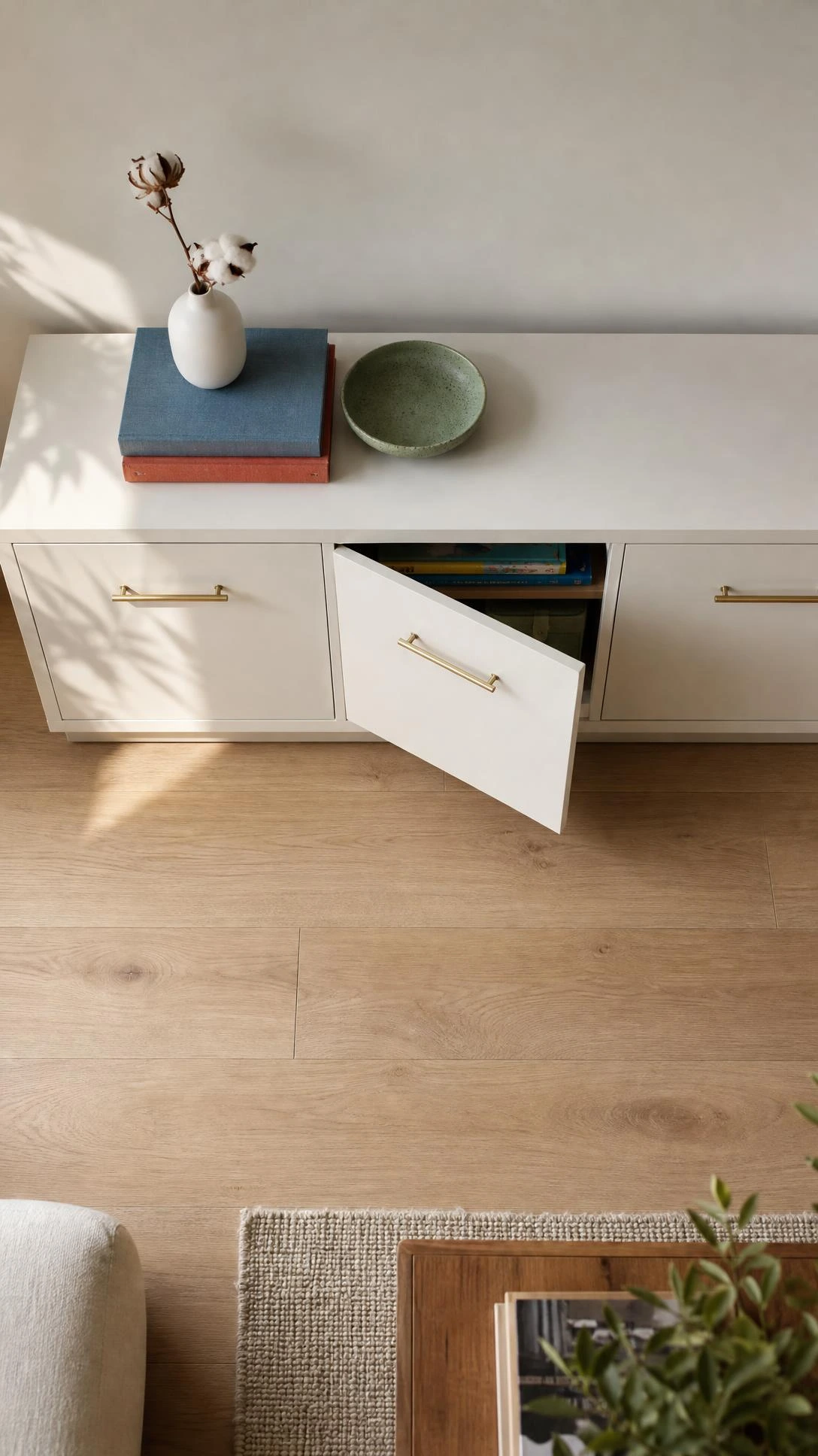 Low-profile white sideboard with closed doors keeping living room toy storage hidden, showing how built-in cabinetry maintains a clutter-free floor