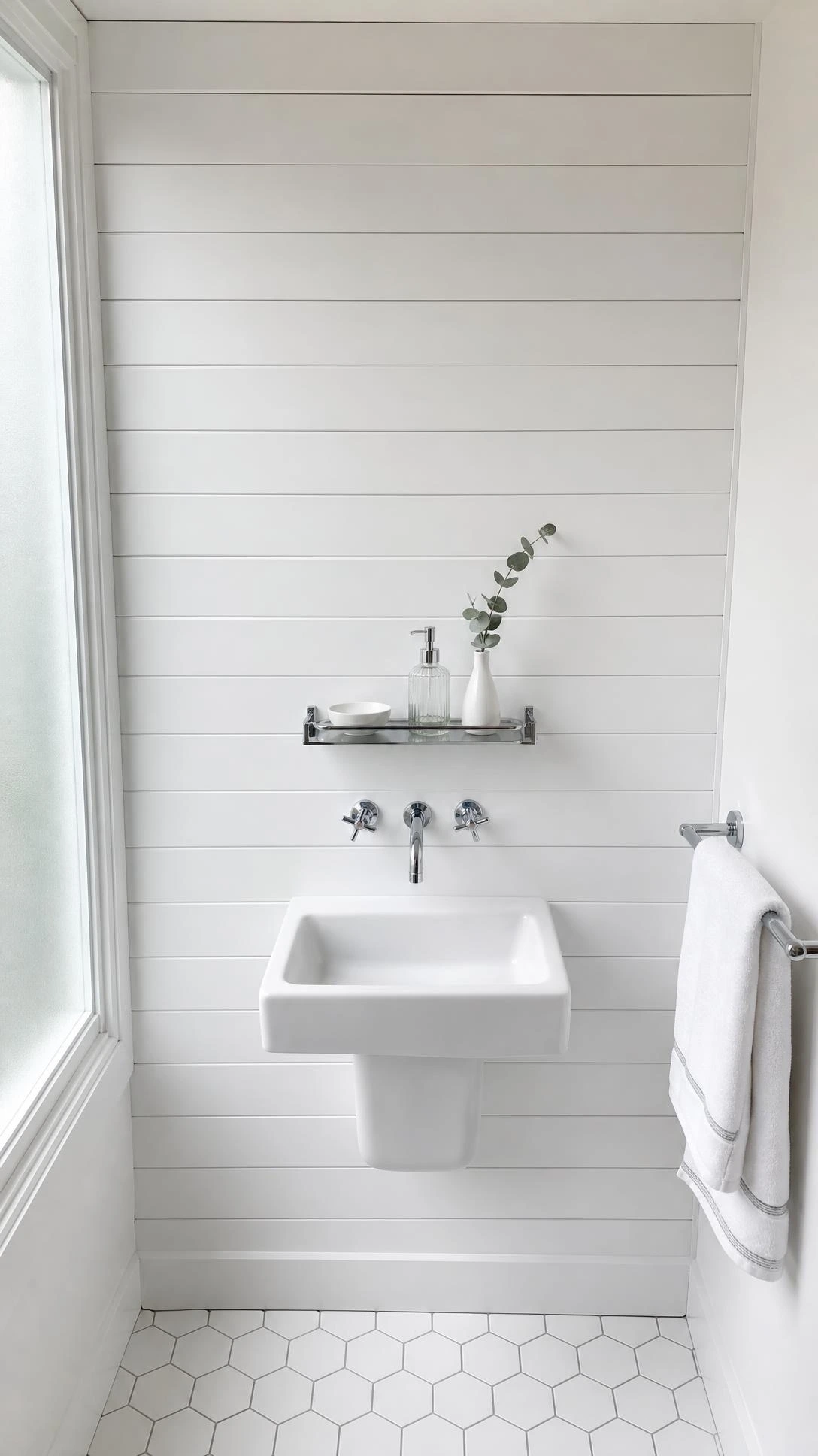 Modern white bathroom with full-height semi-gloss shiplap accent wall behind a wall-mounted pedestal sink, showing crisp horizontal plank lines from baseboard to ceiling