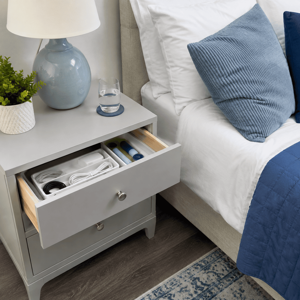 Bedside table with closed storage and organized charging cables