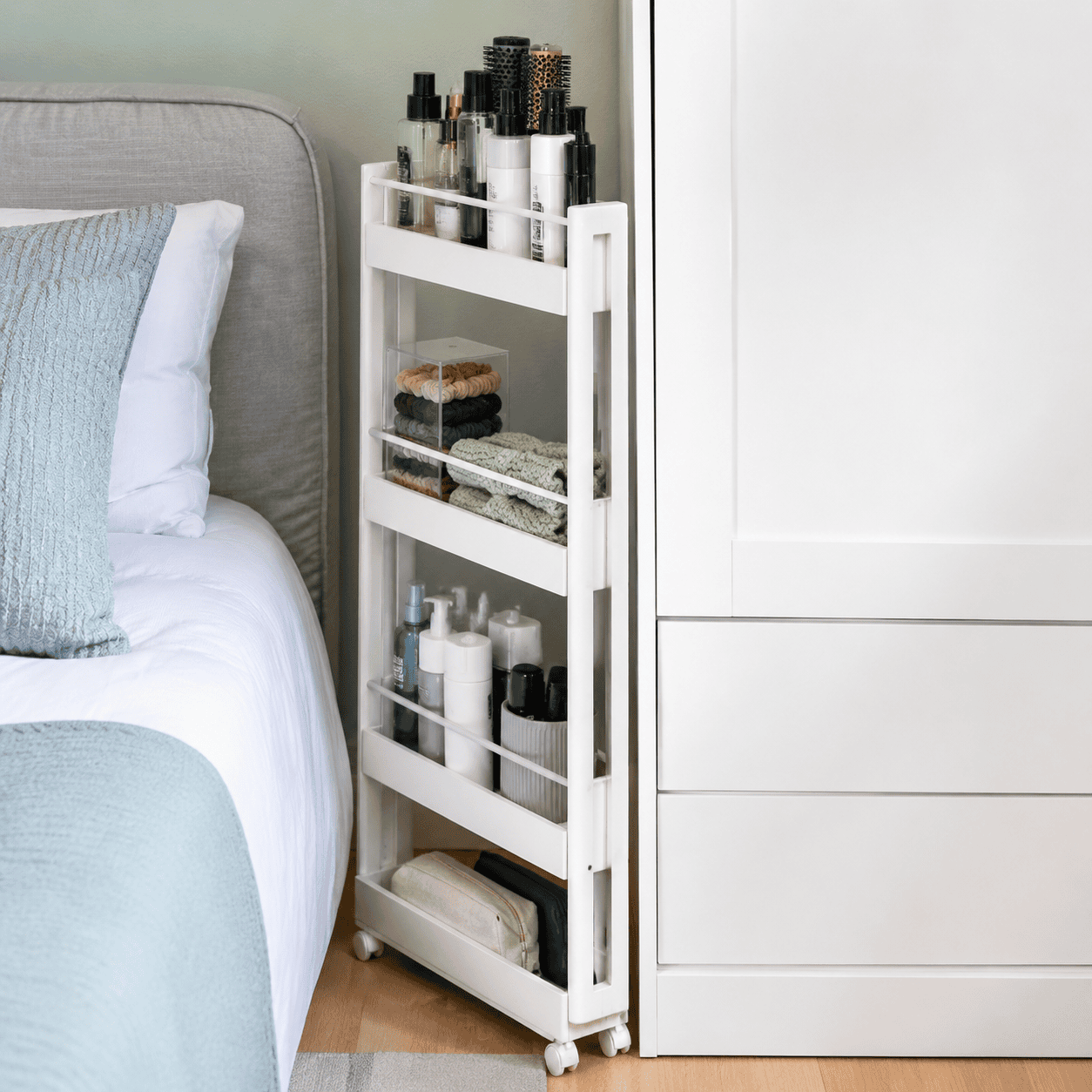 Narrow rolling storage cart beside a bedroom wardrobe