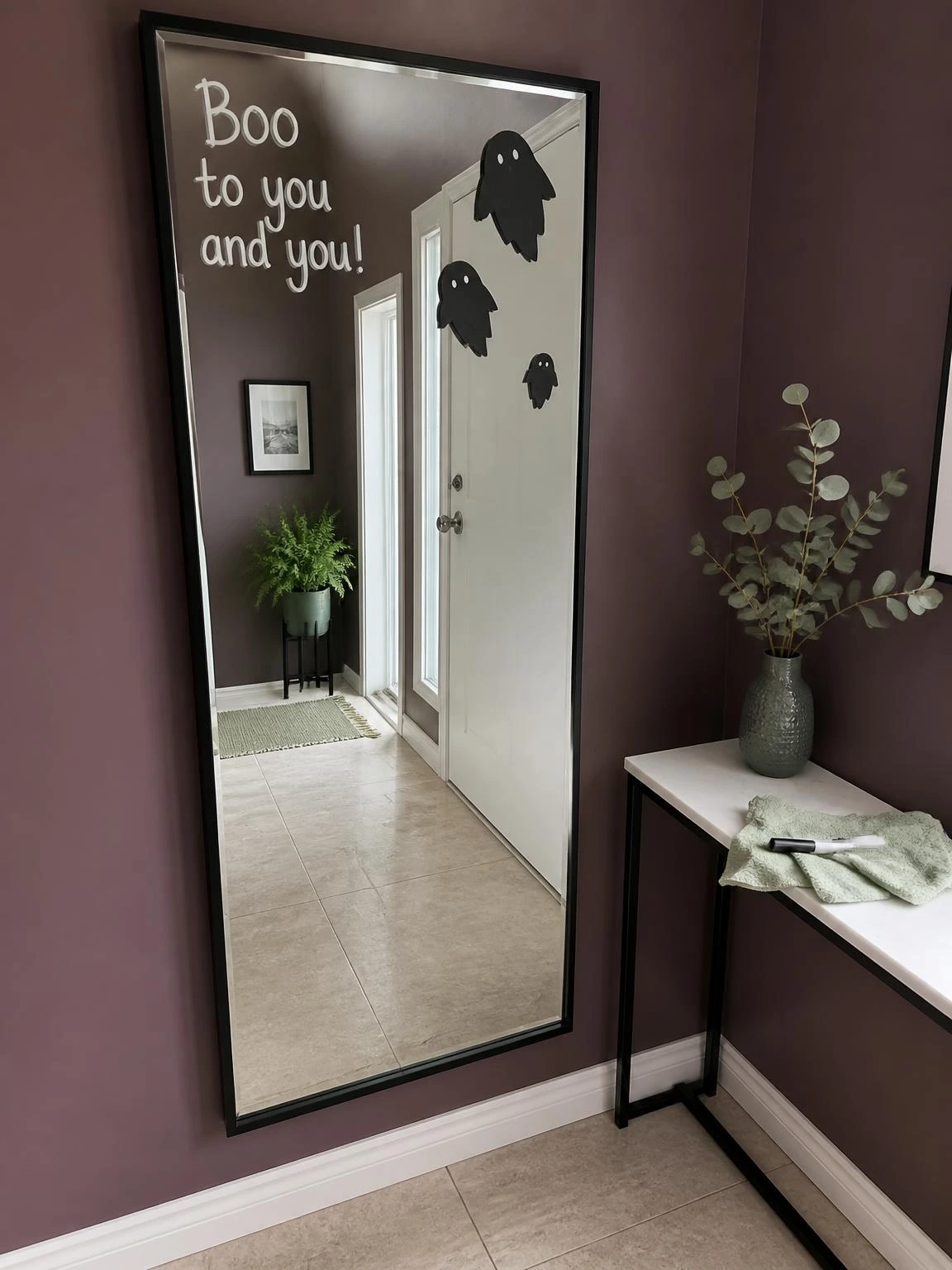 Spooky mirror decoration with removable Halloween message and cardstock ghosts in a compact plum hallway, ideal for cheap DIY Halloween decorations indoor