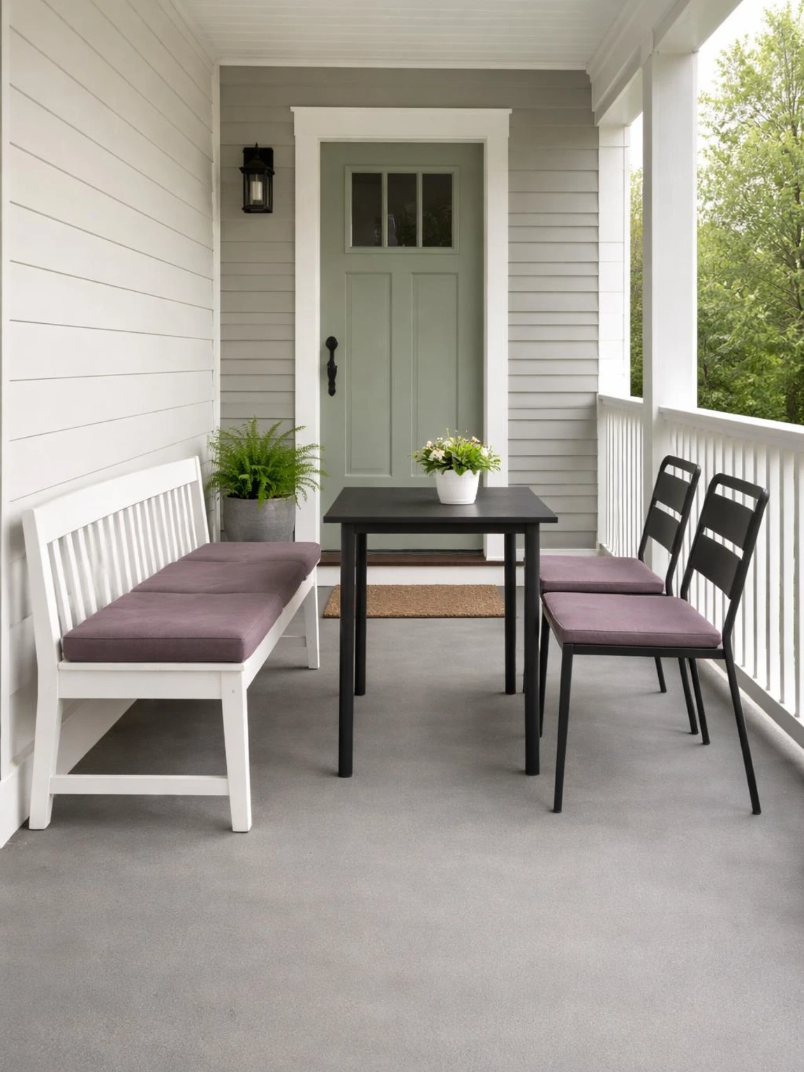 Front porch furniture with a painted bench and two dining chairs around a small table shows flexible seating on a narrow porch.