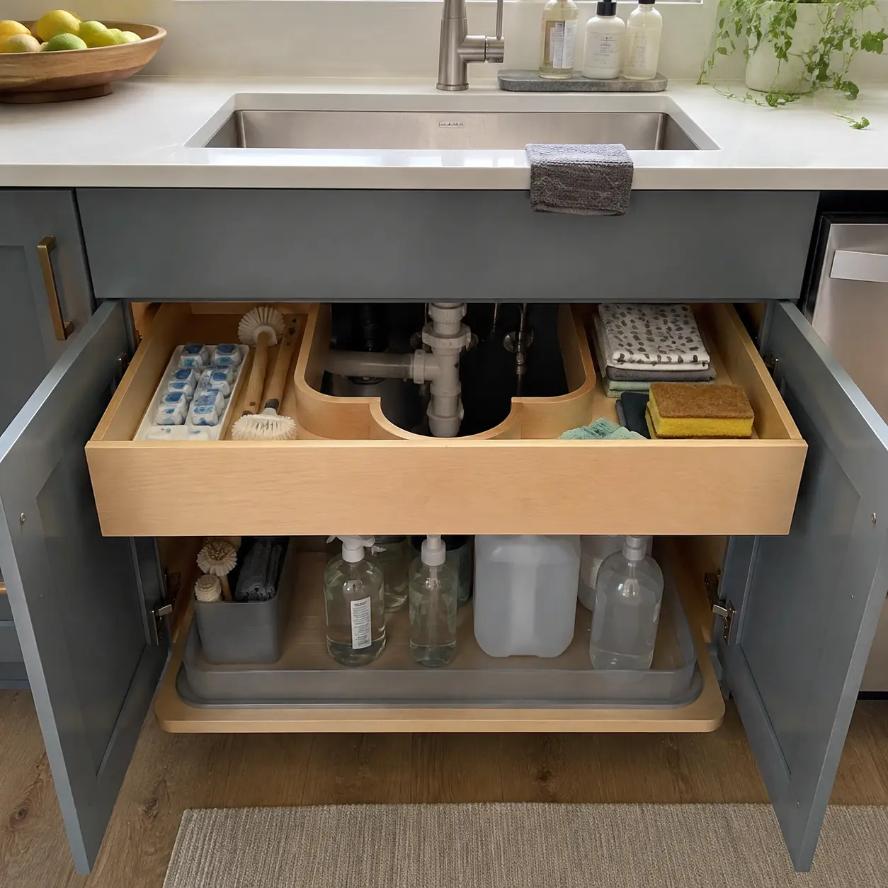 U-shaped under-sink drawer fitted around plumbing for cleaning supplies